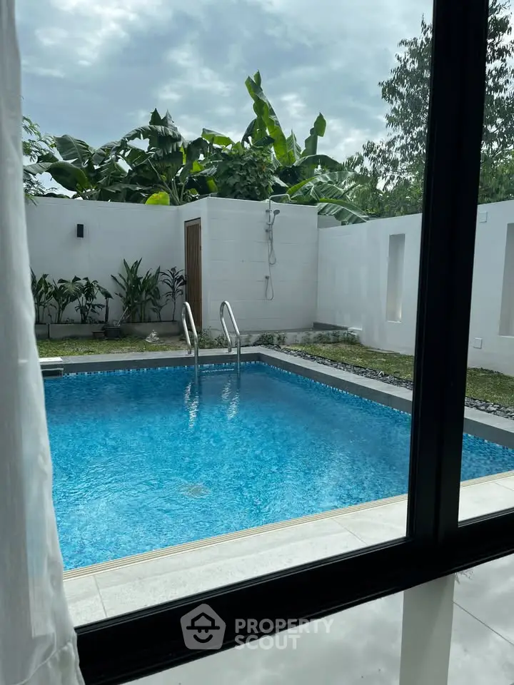 Luxurious private pool view from modern villa with lush greenery
