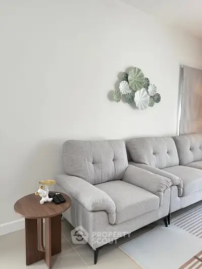 Modern living room with stylish gray sofa and decorative wall art