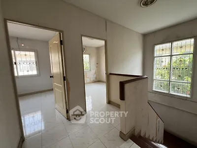 Spacious upper floor hallway with natural light and potential for renovation