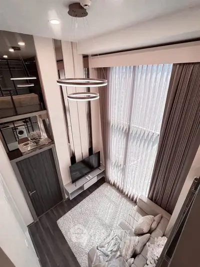 Stunning modern living room with high ceilings, large windows, and elegant lighting fixtures.