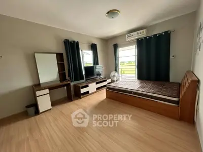 Spacious bedroom with modern furnishings and large windows offering natural light.