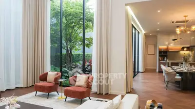 Luxurious living room with high ceilings and garden view, featuring elegant decor and open layout.