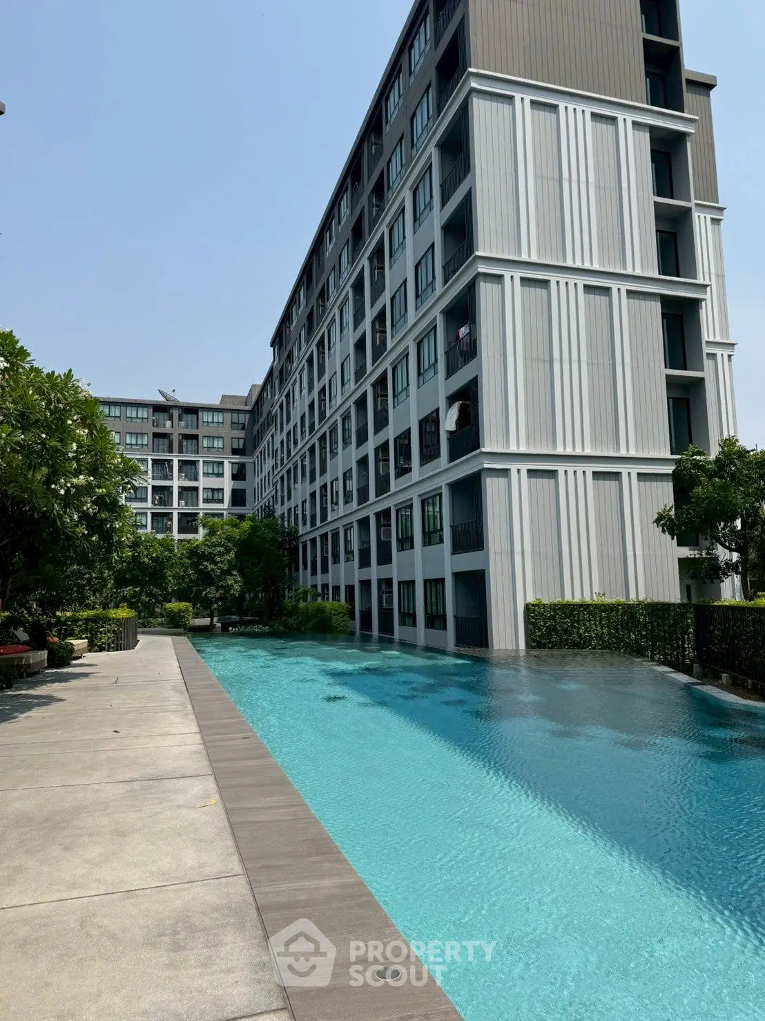 Modern condominium with stunning poolside view and lush greenery