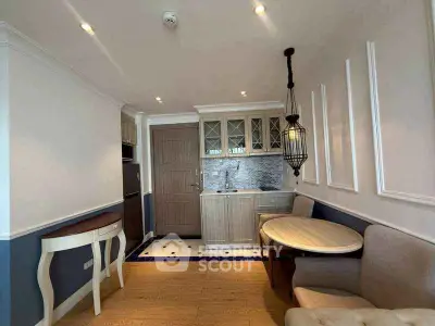 Charming kitchen with elegant cabinetry and cozy dining area in a stylish apartment.