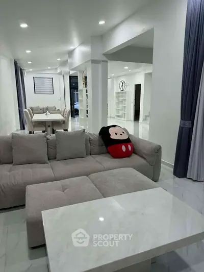 Spacious modern living room with plush sofa and elegant dining area, perfect for family gatherings.