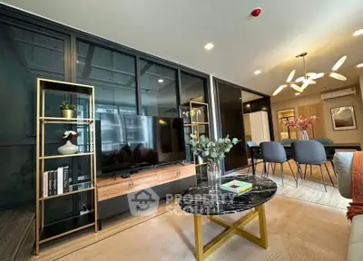 Modern living room with stylish decor and open layout, featuring a sleek TV unit and elegant dining area.