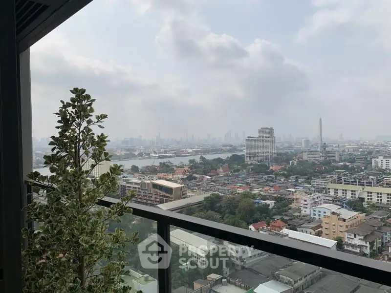 Stunning cityscape view from a high-rise balcony with glass railing.
