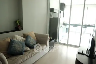 Modern living room with cozy sofa and open kitchen layout, perfect for urban living.