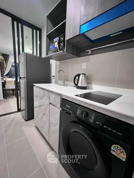 Modern kitchen with sleek appliances and stylish cabinetry in a contemporary apartment.