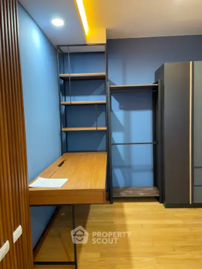 Modern study room with built-in desk and shelving, featuring sleek design and ample storage space.