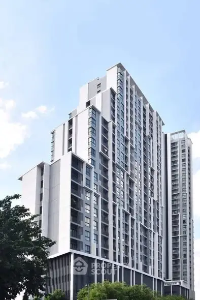 Modern high-rise building with sleek architecture and large windows in urban setting.