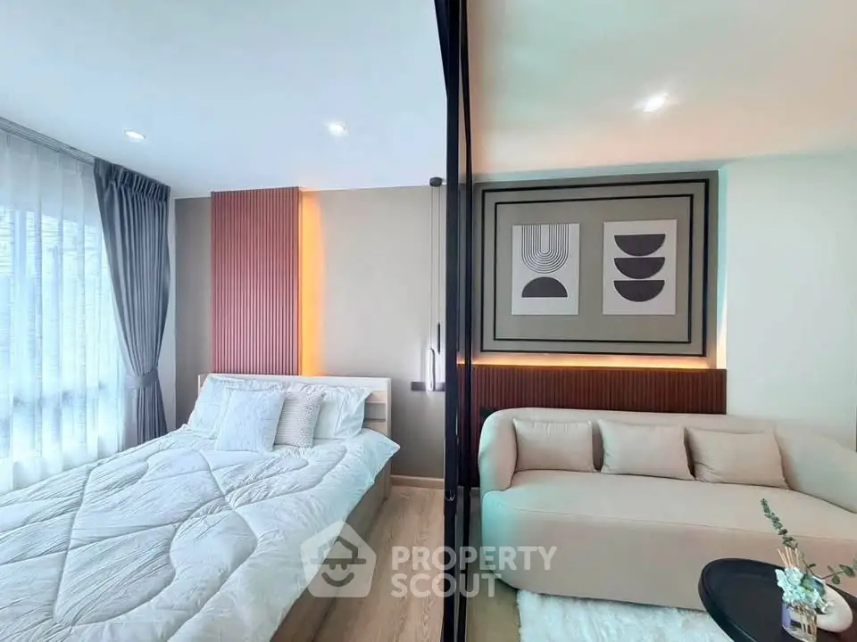 Modern bedroom with stylish decor and cozy seating area, featuring elegant lighting and contemporary artwork.