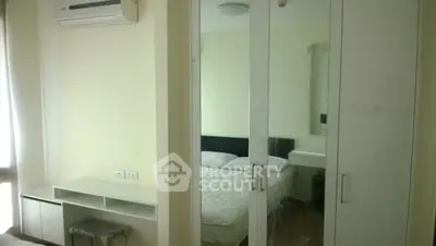 Modern bedroom with mirrored wardrobe and air conditioning unit