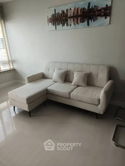 Modern living room with stylish white sofa and cityscape artwork