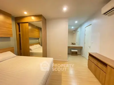Spacious bedroom with modern wooden furniture and cozy lighting