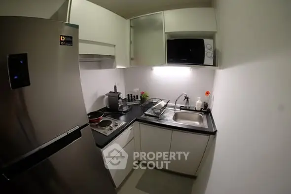 Compact modern kitchen with stainless steel appliances and sleek cabinetry