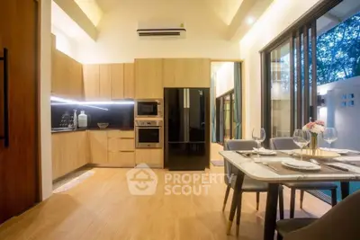 Modern kitchen and dining area with sleek appliances and elegant table setting.