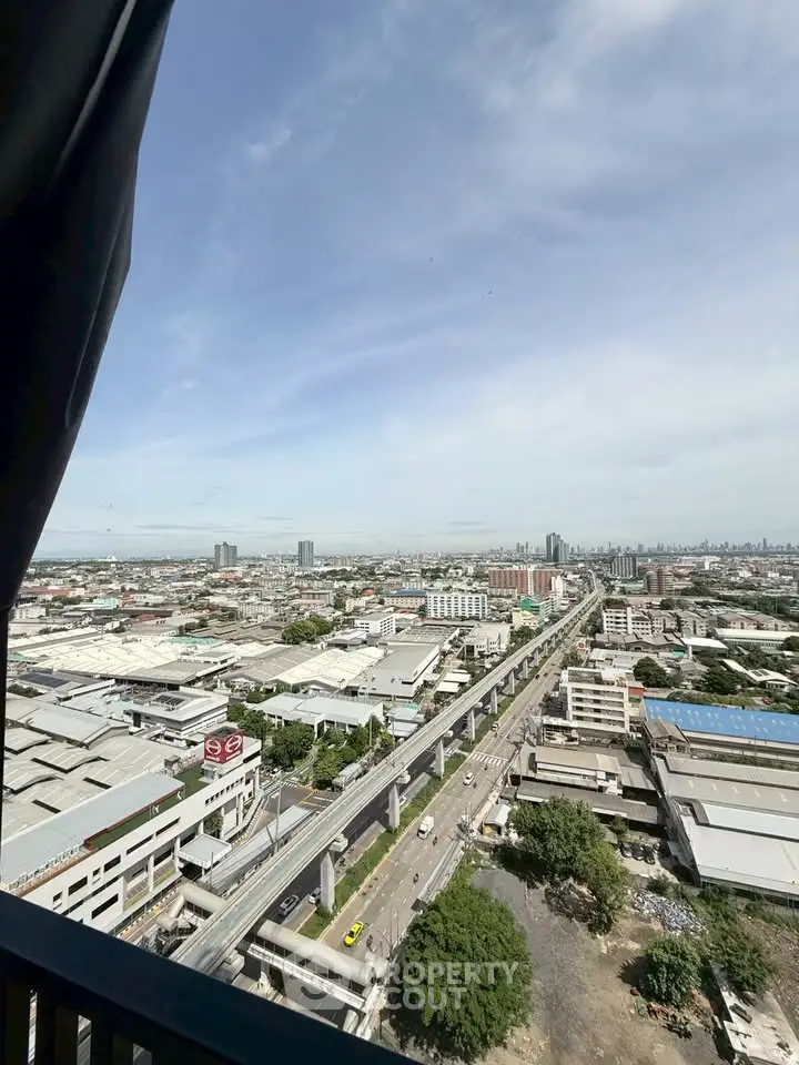 Stunning cityscape view from high-rise building overlooking urban skyline and highway.