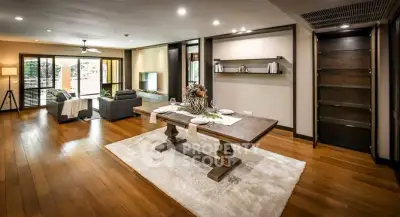 Spacious open-plan living and dining area with elegant wooden flooring and modern decor.