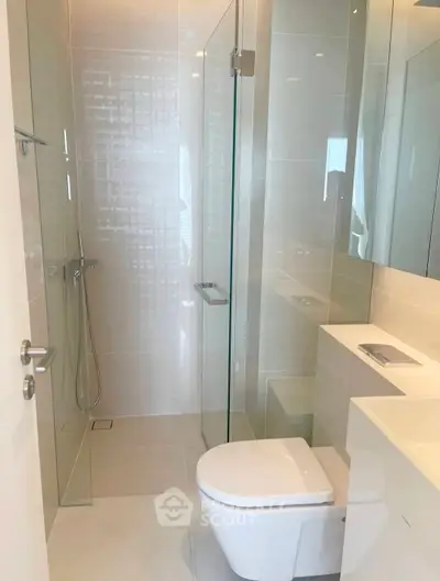Modern bathroom with glass shower and sleek fixtures in a contemporary apartment.