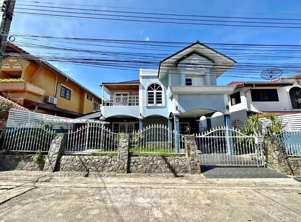Charming two-story house with unique architecture and spacious front yard in a suburban neighborhood.