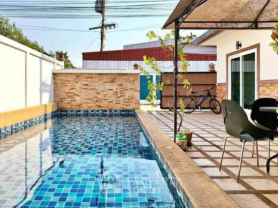 Charming backyard with a sparkling pool and cozy patio area, perfect for relaxation and outdoor activities.