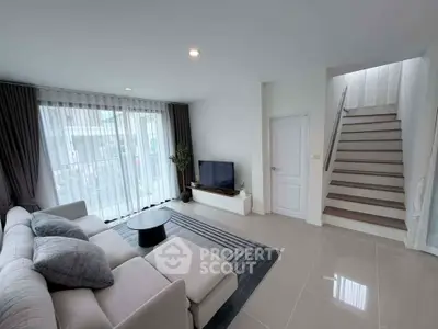 Modern living room with sleek design and natural light, featuring a cozy sofa and stylish decor.