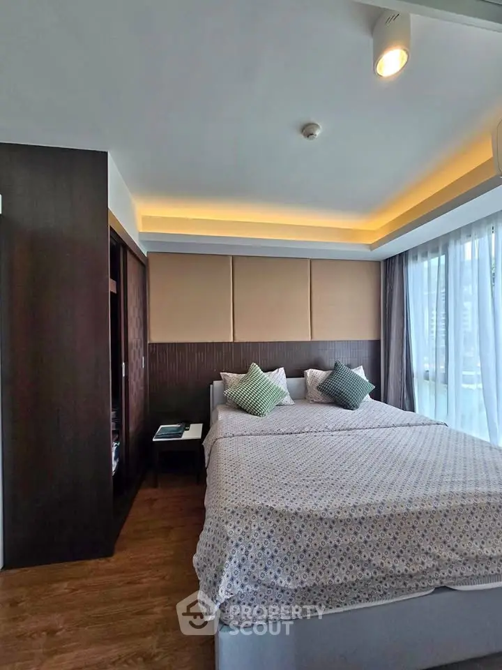 Modern bedroom with stylish decor and large windows offering natural light.