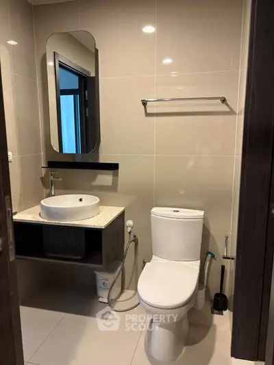 Modern bathroom with sleek fixtures and elegant design, featuring a stylish sink and toilet.