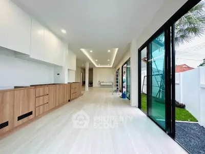 Spacious modern living room with open layout and large sliding glass doors to garden.