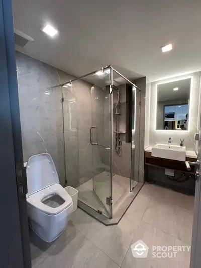 Modern bathroom with glass shower and sleek fixtures in luxury apartment