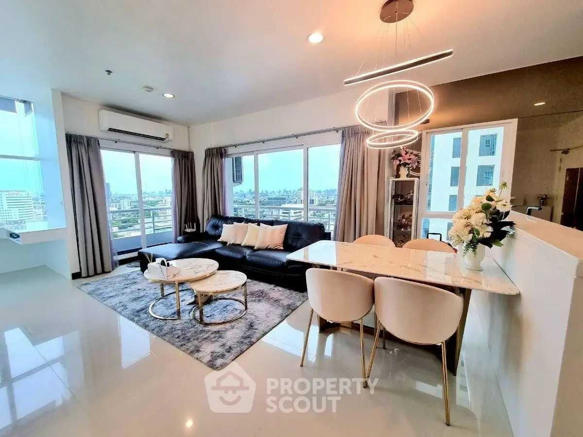 Spacious modern living room with city view, elegant furniture, and stylish lighting in a high-rise apartment.