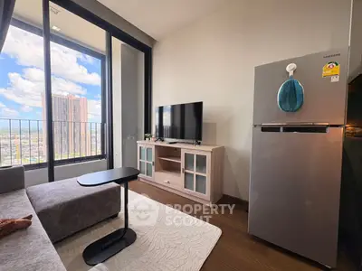 Modern living room with city view, featuring sleek furniture and a stainless steel fridge.