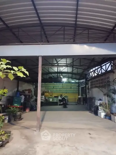 Spacious industrial-style garage with high ceiling and ample storage space.
