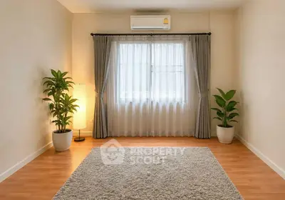 Spacious minimalist room with wooden flooring and large window, perfect for a cozy living space.