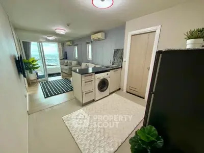Modern open-plan living room with washing machine and balcony view.