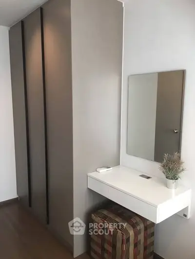 Modern minimalist bedroom with sleek wardrobe and stylish vanity area.