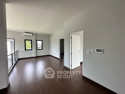 Spacious modern living room with wooden flooring and large windows