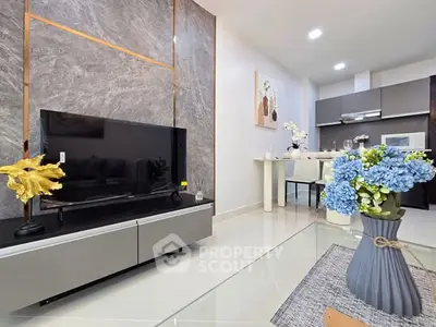 Modern living room with elegant decor and open kitchen layout, featuring sleek furniture and vibrant floral accents.