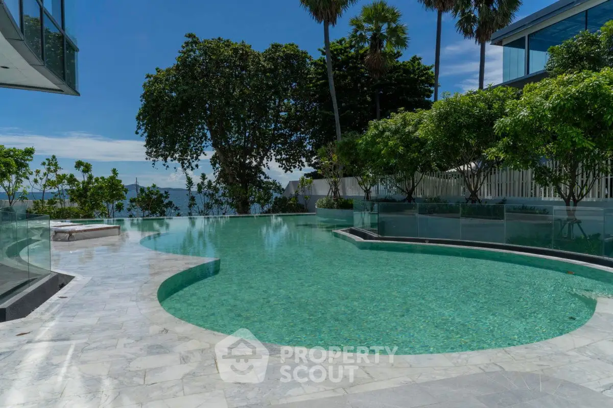 Luxurious outdoor pool with stunning ocean view and lush greenery