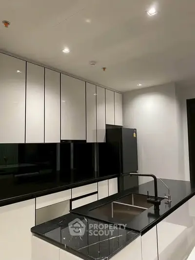 Modern kitchen with sleek black and white cabinetry and island