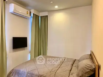 Cozy bedroom with air conditioning and wall-mounted TV, perfect for relaxation.