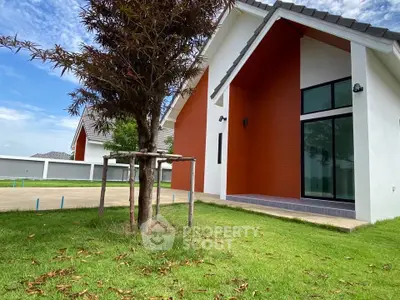 Modern house exterior with lush green lawn and contemporary architecture.