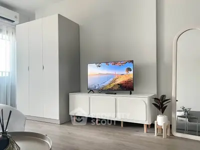 Modern living room with sleek furniture and stylish decor, featuring a TV and wardrobe.