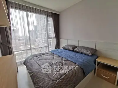 Modern bedroom with large window and city view, featuring cozy bedding and stylish decor.
