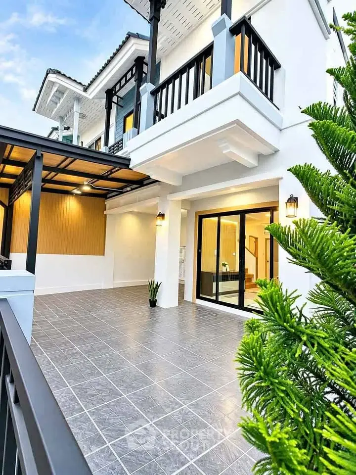 Modern two-story house with spacious tiled patio and elegant balcony.