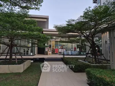Modern building exterior with lush landscaping and glass facade, perfect for commercial or residential use.