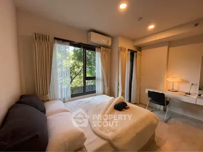 Cozy bedroom with large window and natural light, featuring a comfortable bed and modern desk area.