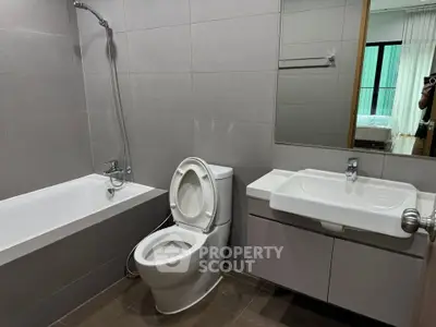 Modern bathroom with sleek fixtures and bathtub in contemporary apartment.