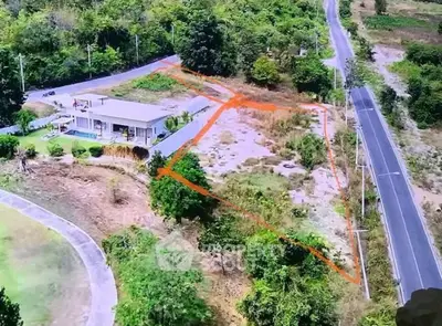 Aerial view of a property with outlined land area and surrounding roads.
